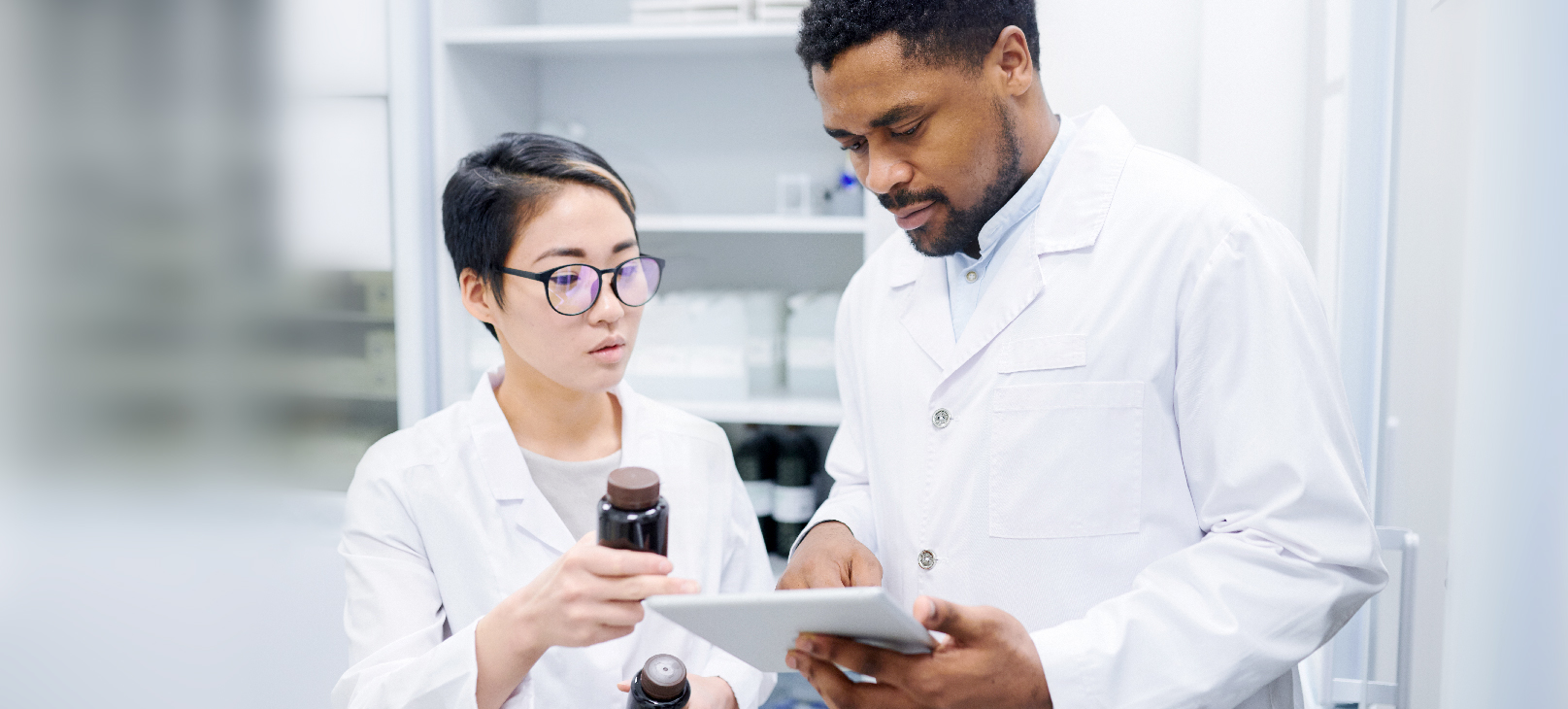 dois-farmacêuticos-vestindo-jaleco-branco-utilizando-a-tecnologia-na-industria-farmaceutica
