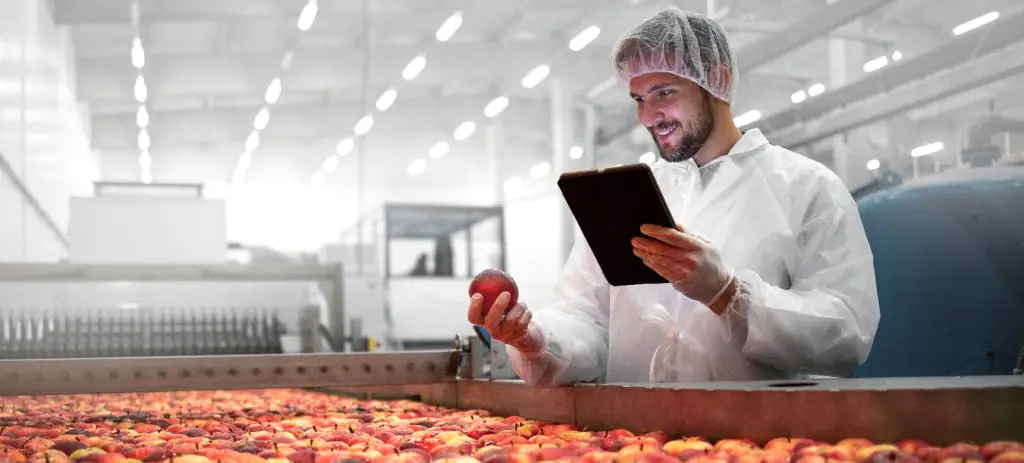 profissional-analisando-fruta-na-cadeia-produtiva-da-indústria-de-alimentos-e-bebidas