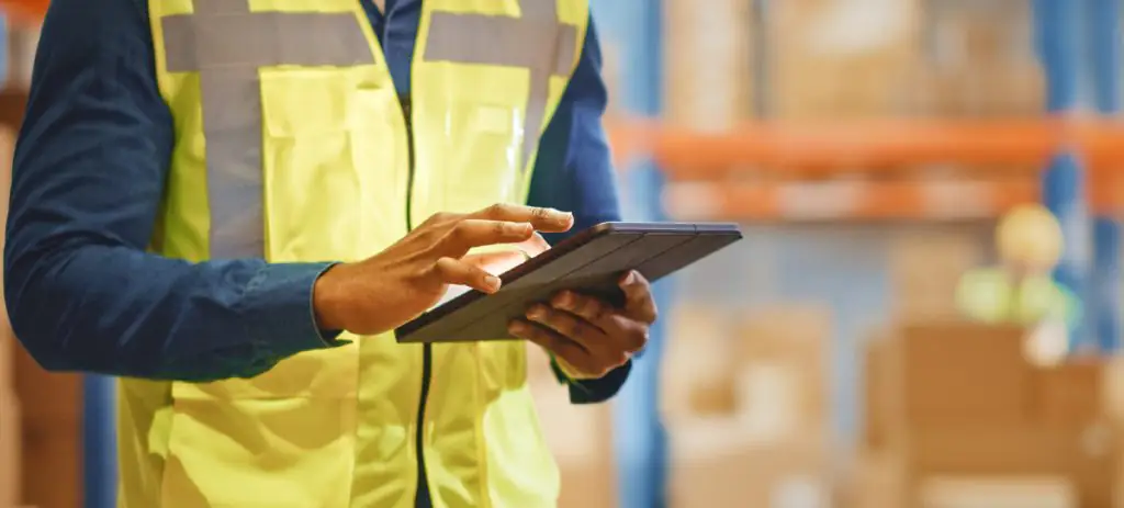 homem-vestindo-colete-amarelo-usando-tablet