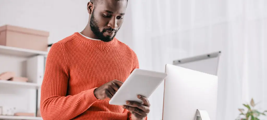homem-vestindo-camisa-laranja-analisando-a-nota-fiscal-de-remessa